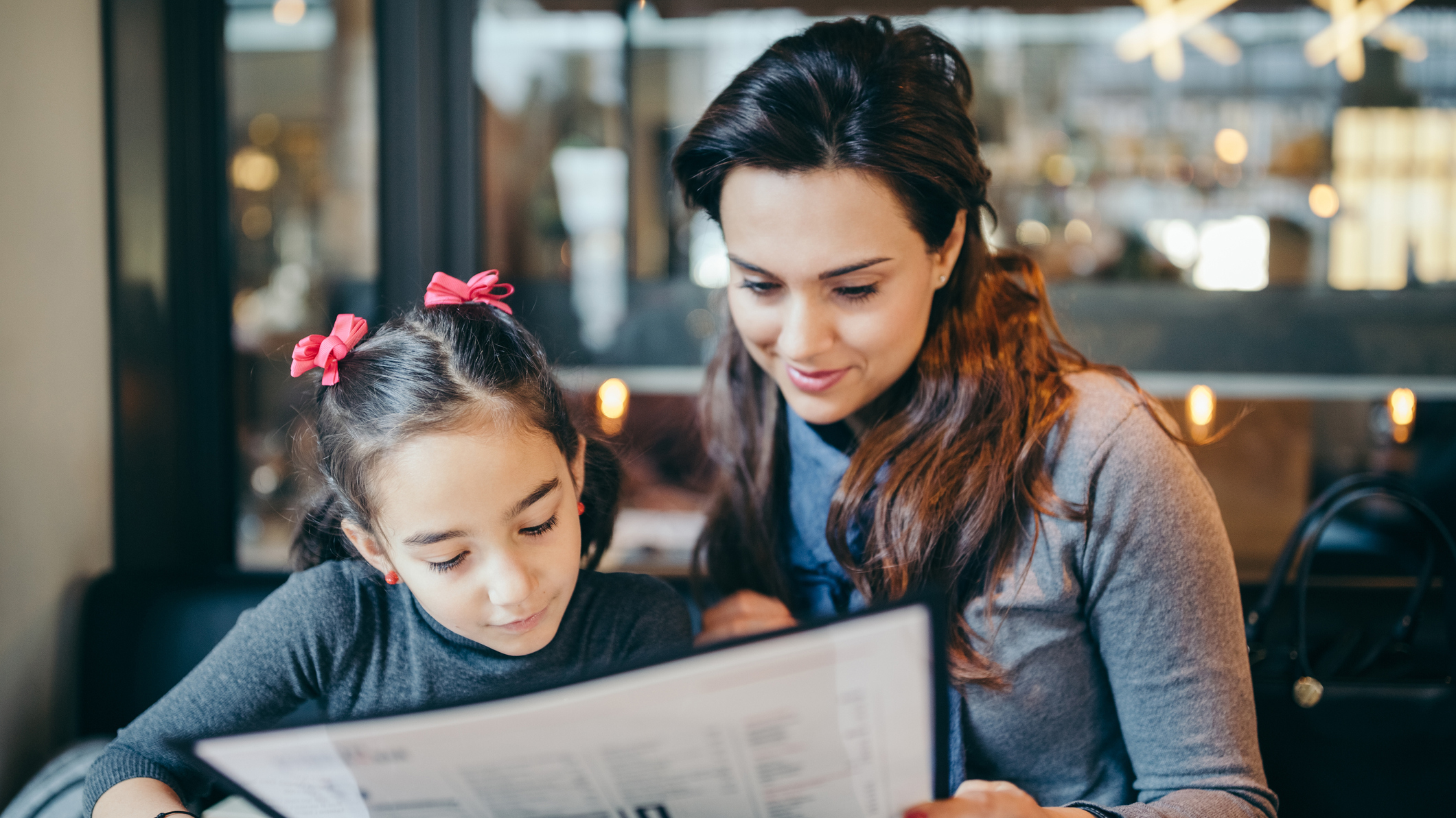 Mother and daughter read a menu together