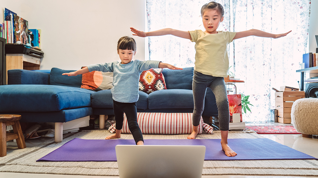 Siblings do yoga in the living room