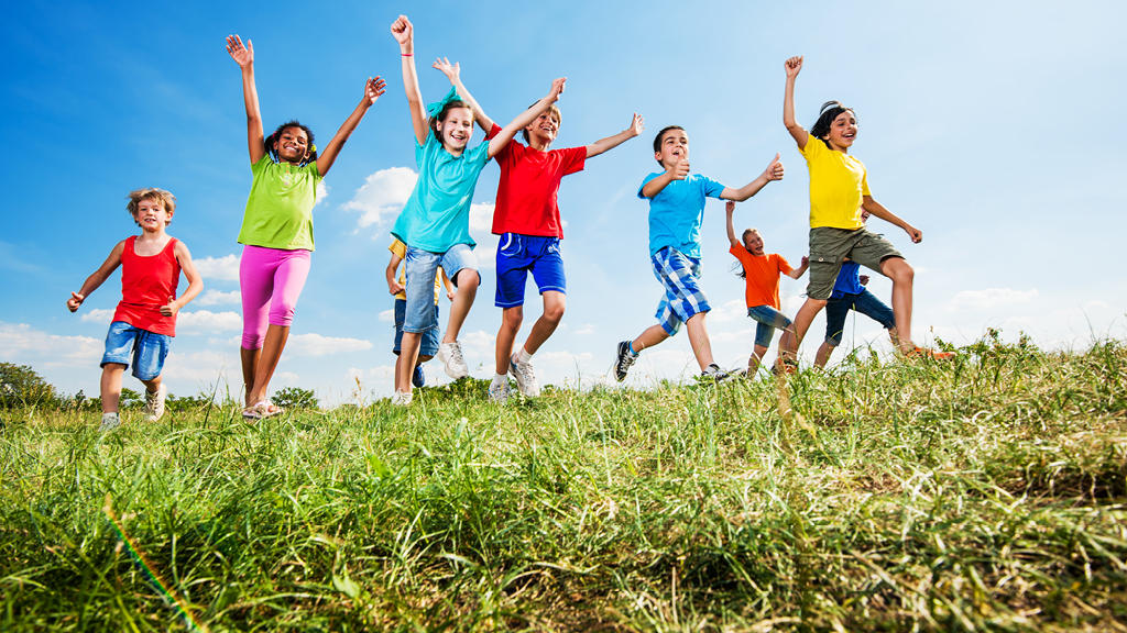 Kids running outside on a field of grass