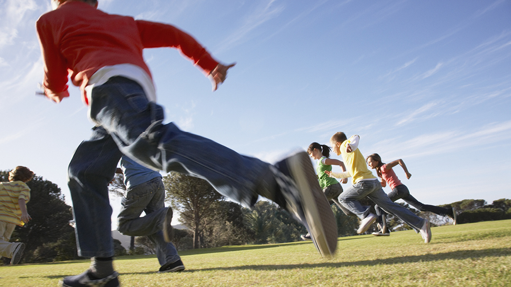 kids playing a game outside on a grassy field