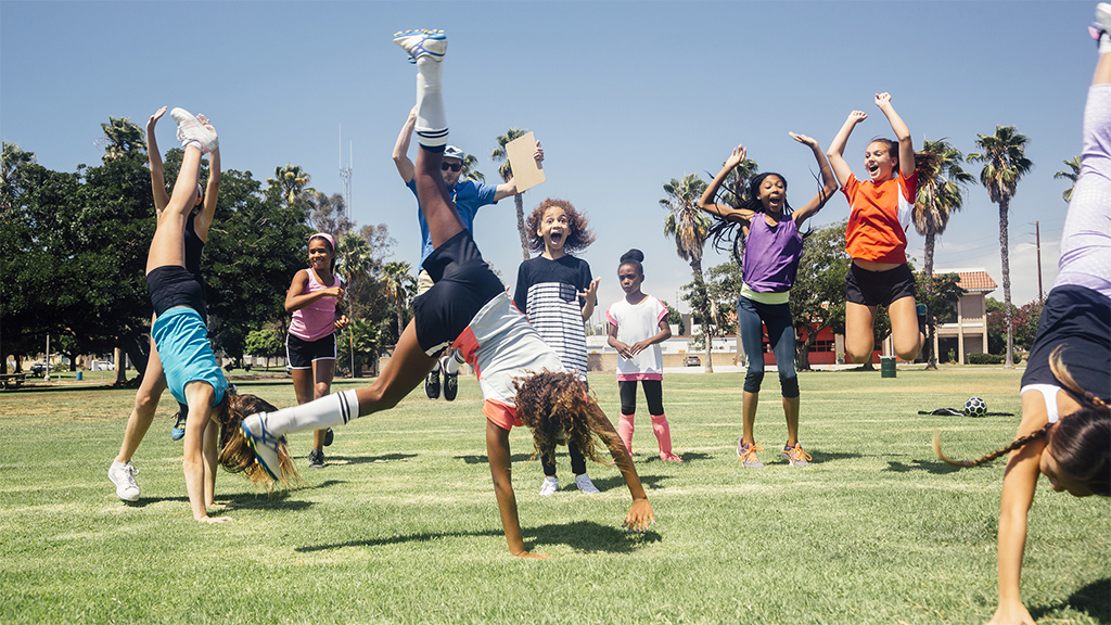 Group of kids doing movement activities on a field outside