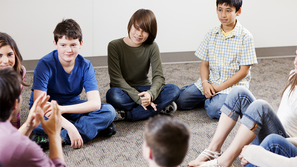 Group of kids sitting in a circle having a discussion