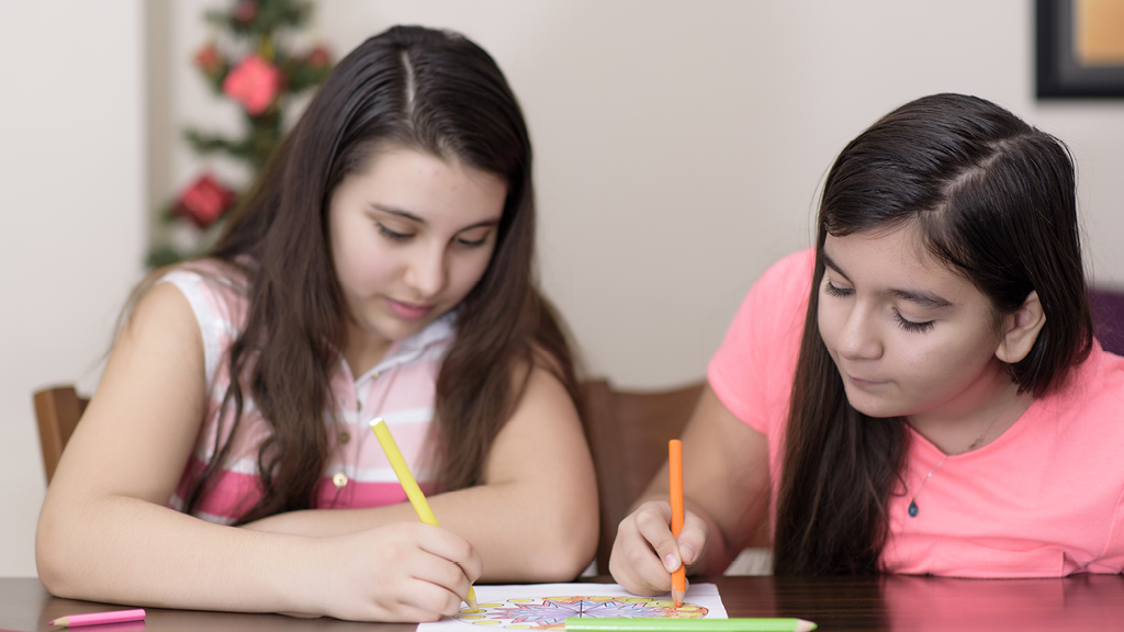 girls writing on a piece of paper