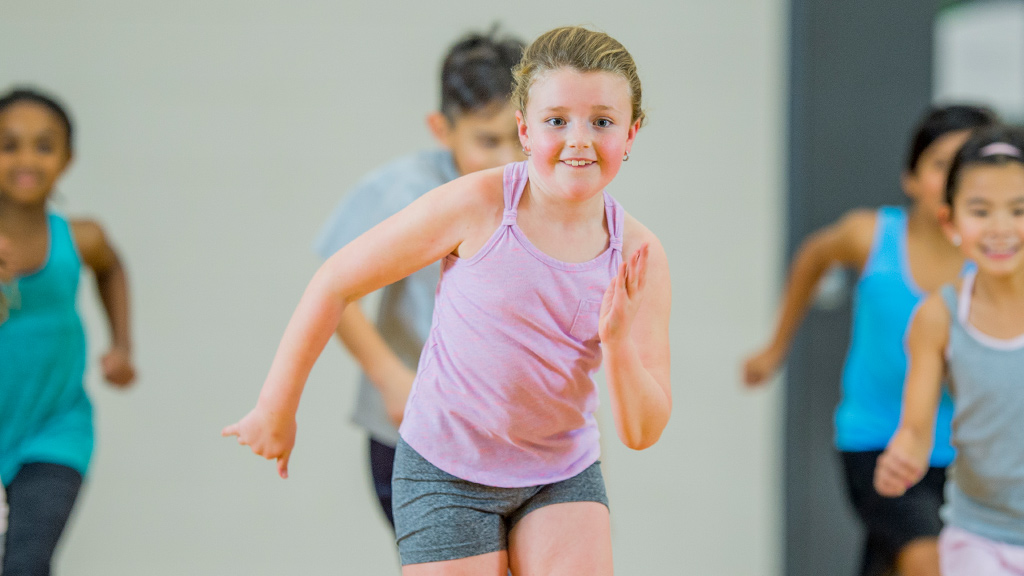 smiling kids running in a gym