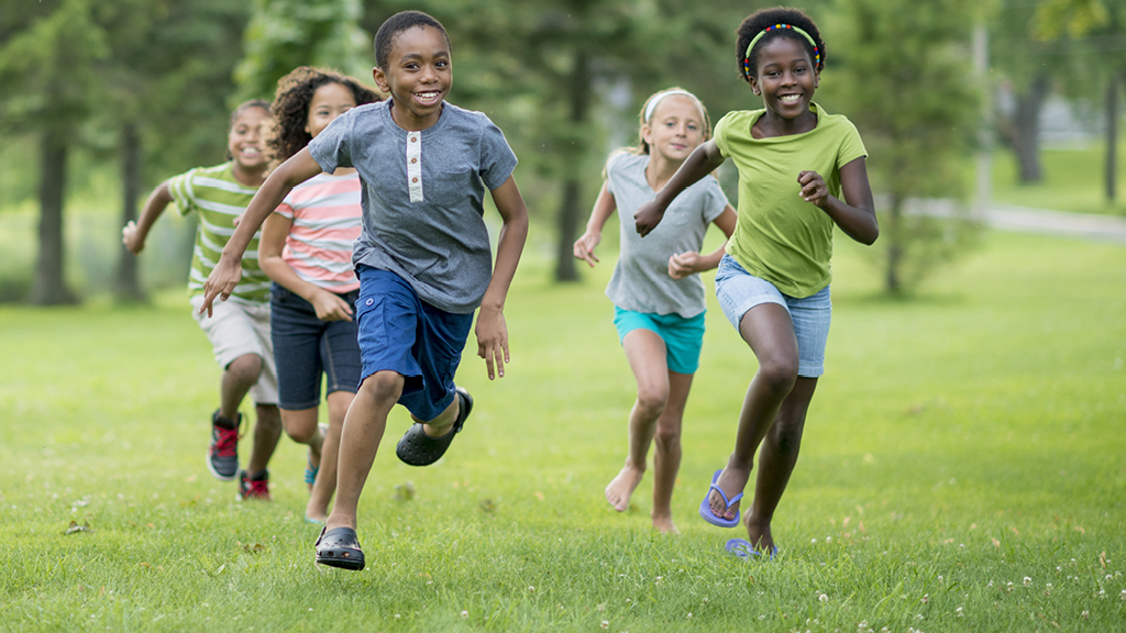 Group of kids playing a game on a grassy field 