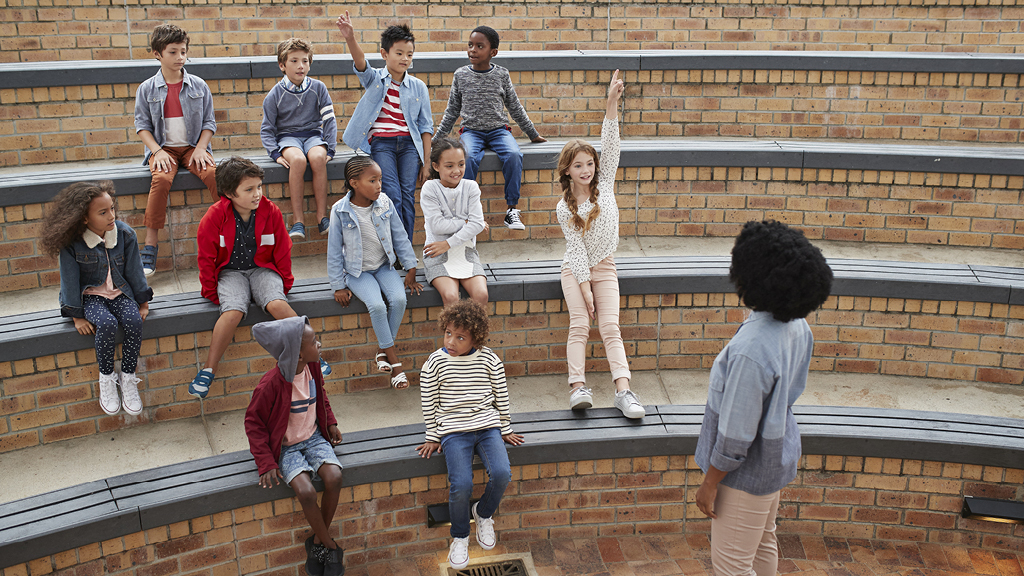 Group of children having a discussion with an adult leader