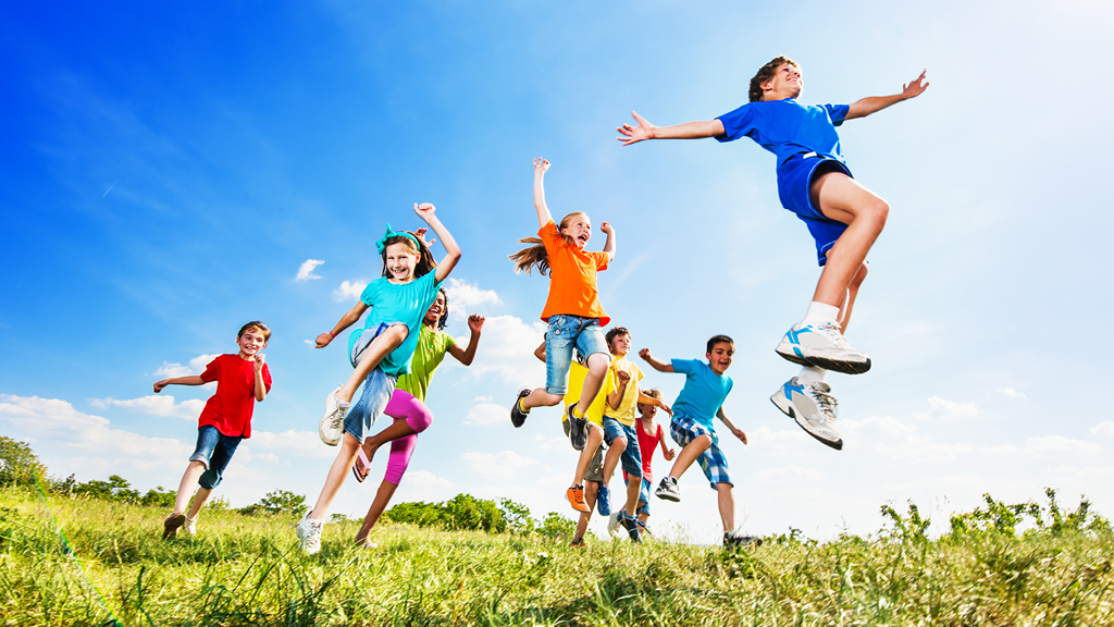 Group of kids playing on grassy field outside