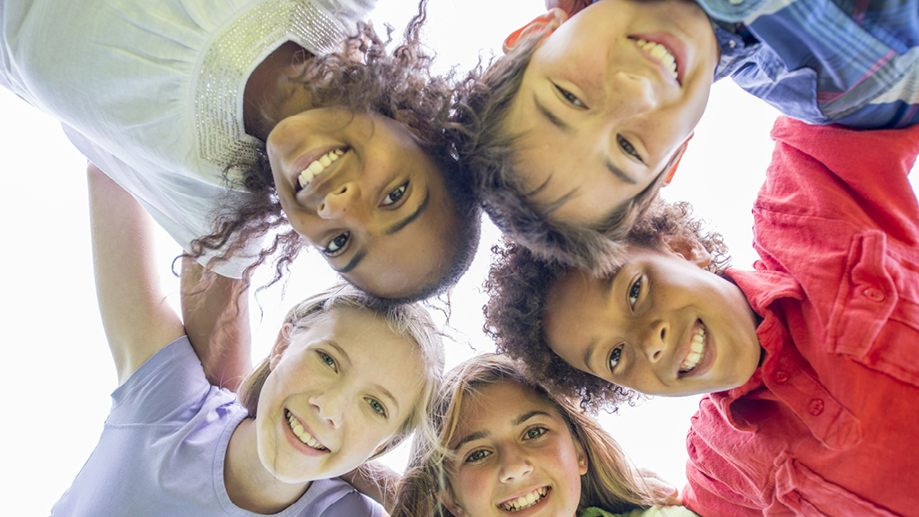 smiling kids standing in a circle 