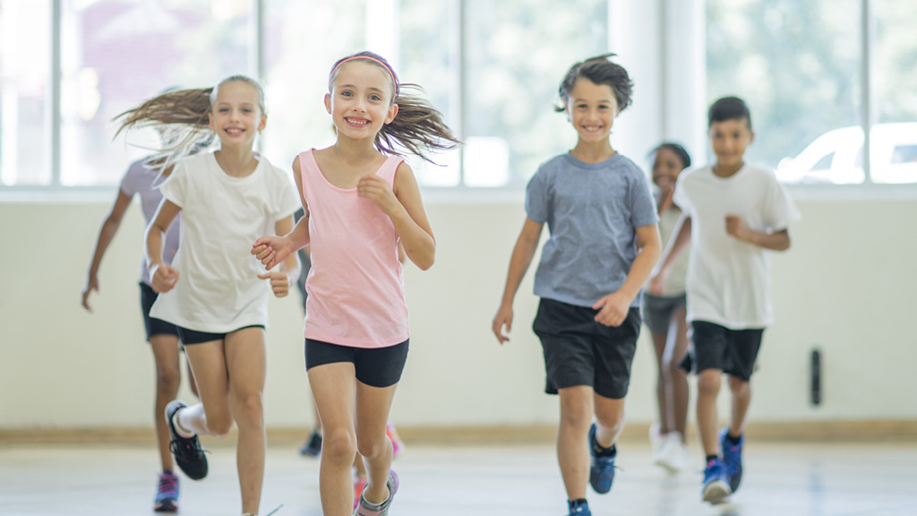group of kids running a relay in a gym