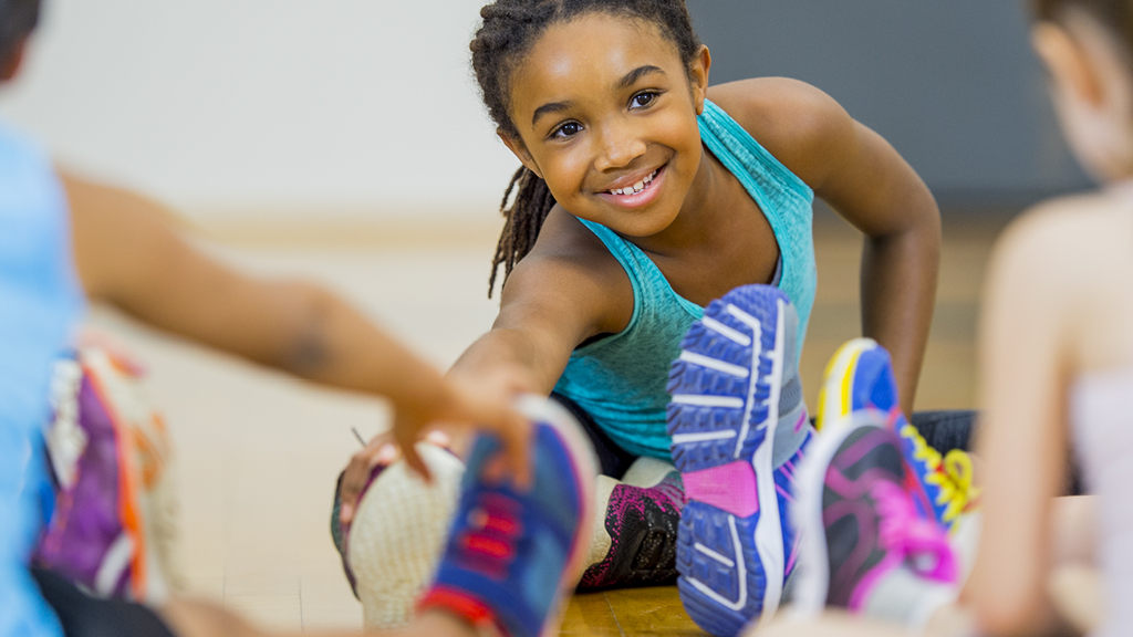 girl stretching and touching her toes in a gym
