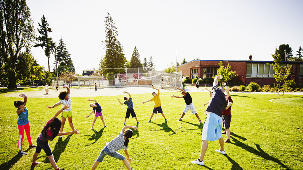 group of kids exercising on grassy field