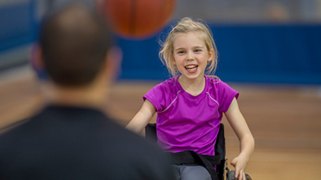 girl in wheelchair playing catch