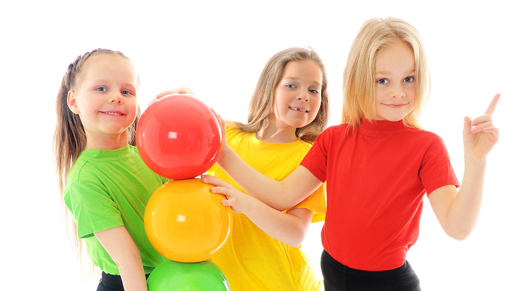 girls holding red, yellow, and green balls to make a stoplight