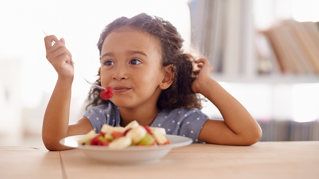 Child eating healthy fruit - Sanford fit