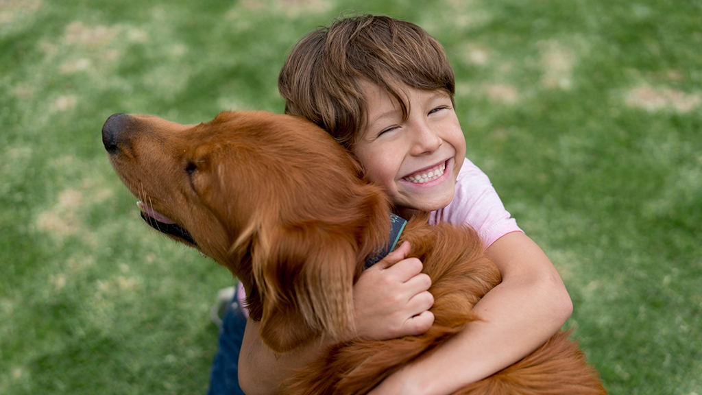 Happy child hugging dog - Sanford fit